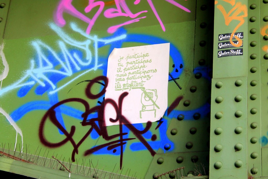 grüne Wand aus Metall mit Graffiti